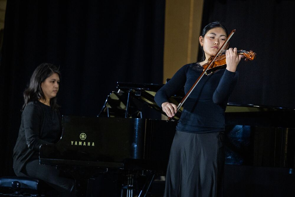 A violinist performs with her piano accompanist.
