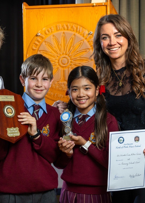 Two young winners hold their trophy and certificate.